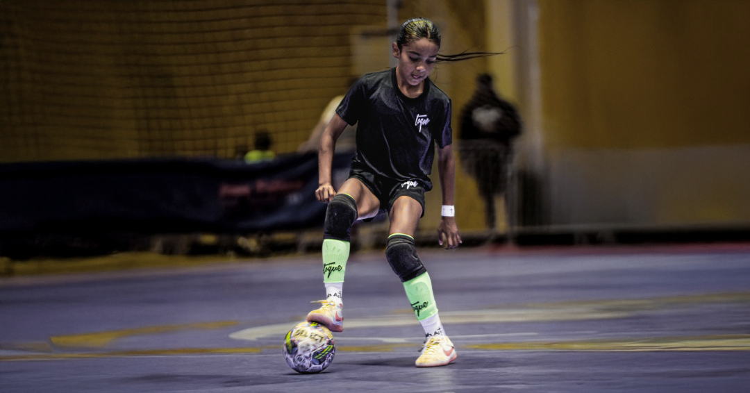 Person playing soccer indoors on a court